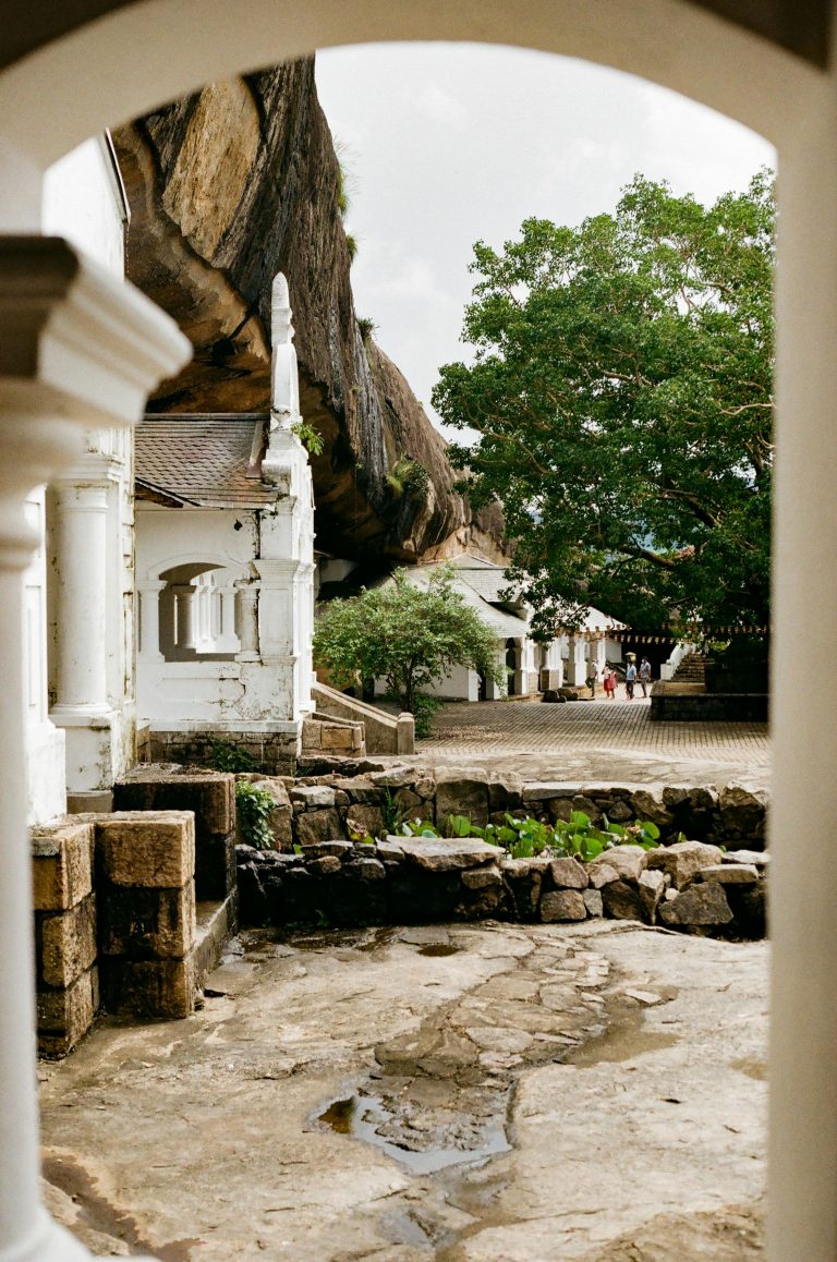 View of the historic Dambulla Cave Temple with ancient stone structures in Sri Lanka.