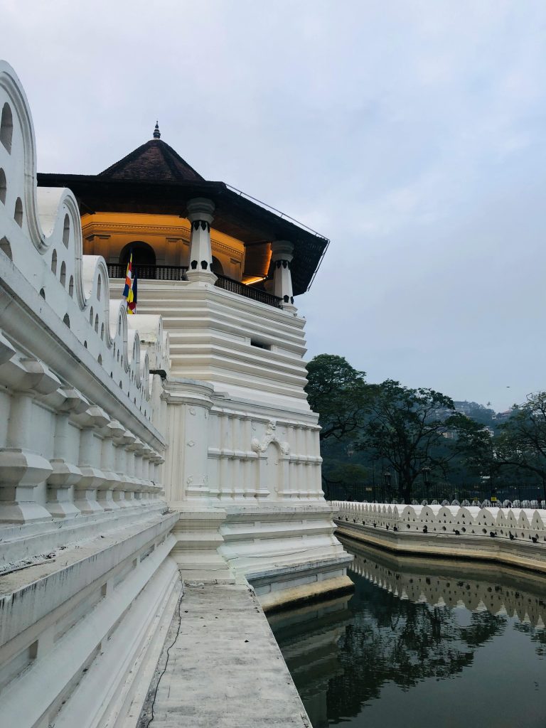 A captivating view of the Temple of the Tooth in Kandy, Sri Lanka reflecting in the water.